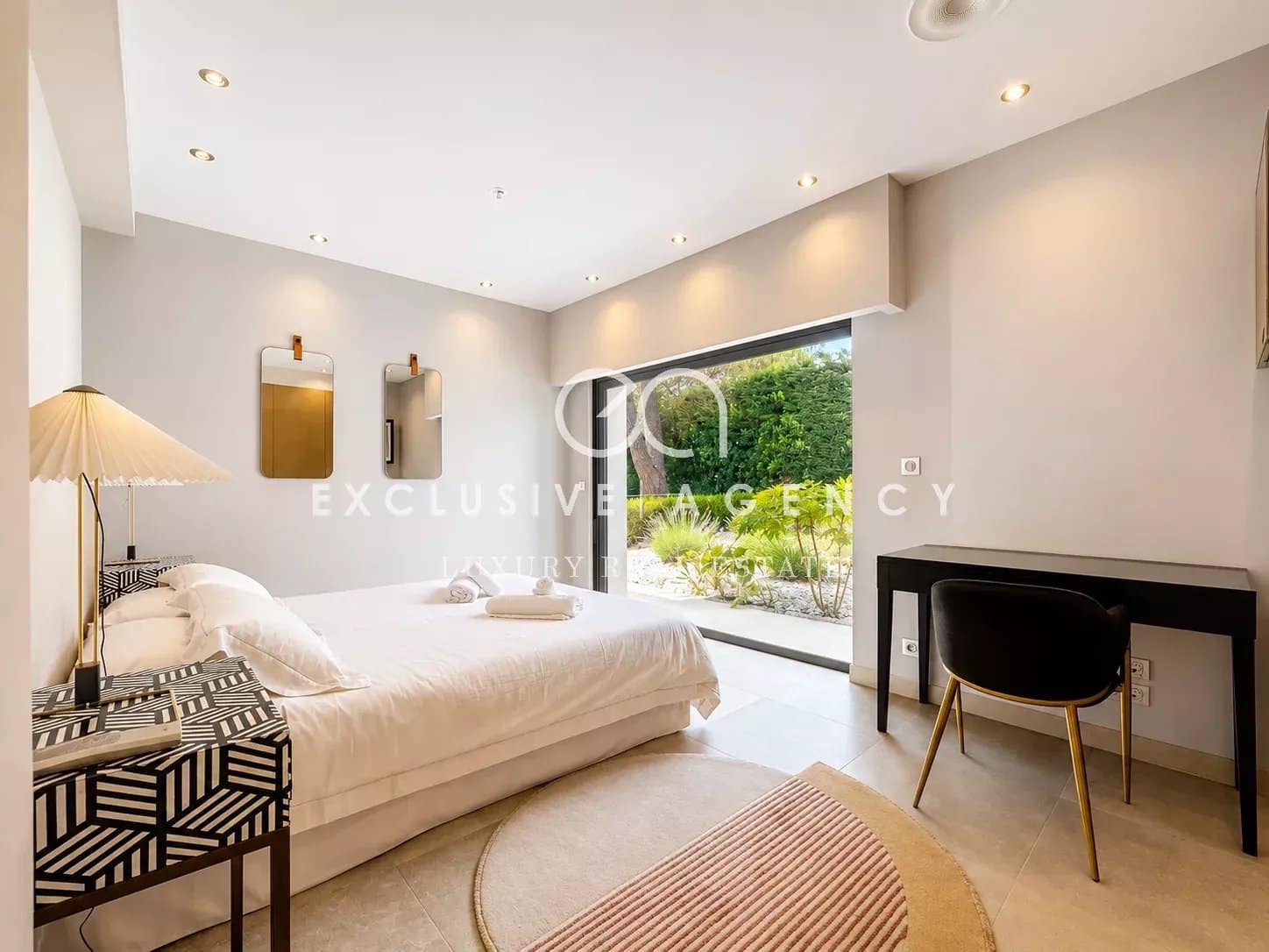 Chambre moderne avec lit double et accès à un jardin, dans une villa californienne à Cannes.