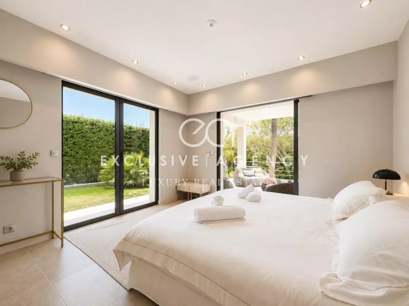 Chambre lumineuse avec lit double et accès à un jardin, villa californienne à Cannes.