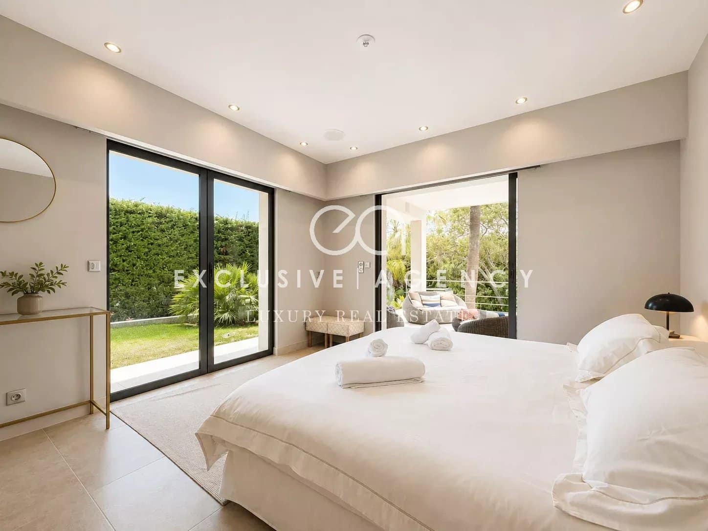 Chambre lumineuse avec lit double et accès à un jardin, villa californienne à Cannes.