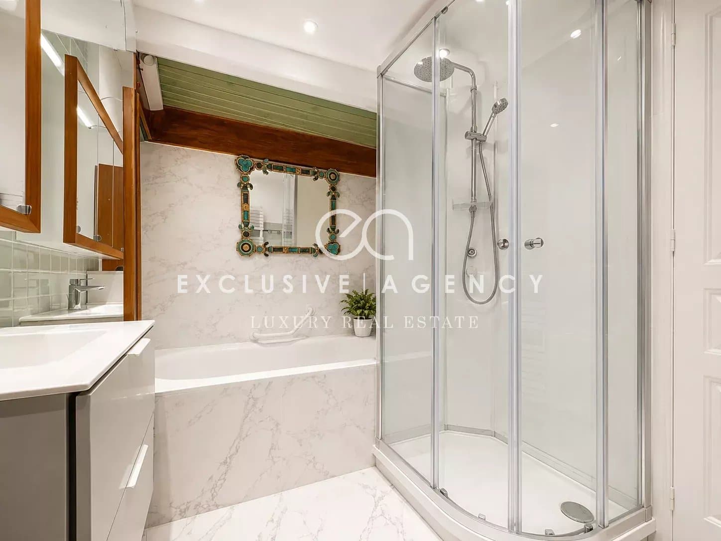 Salle de bain d’un appartement à Cannes Salle de bain moderne avec douche et baignoire, murs en marbre.