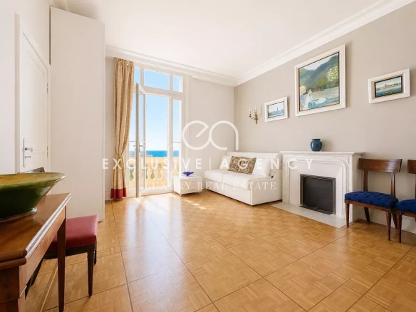 Salon lumineux d'un appartement à Cannes avec vue mer, parquet au sol et décoration sobre.