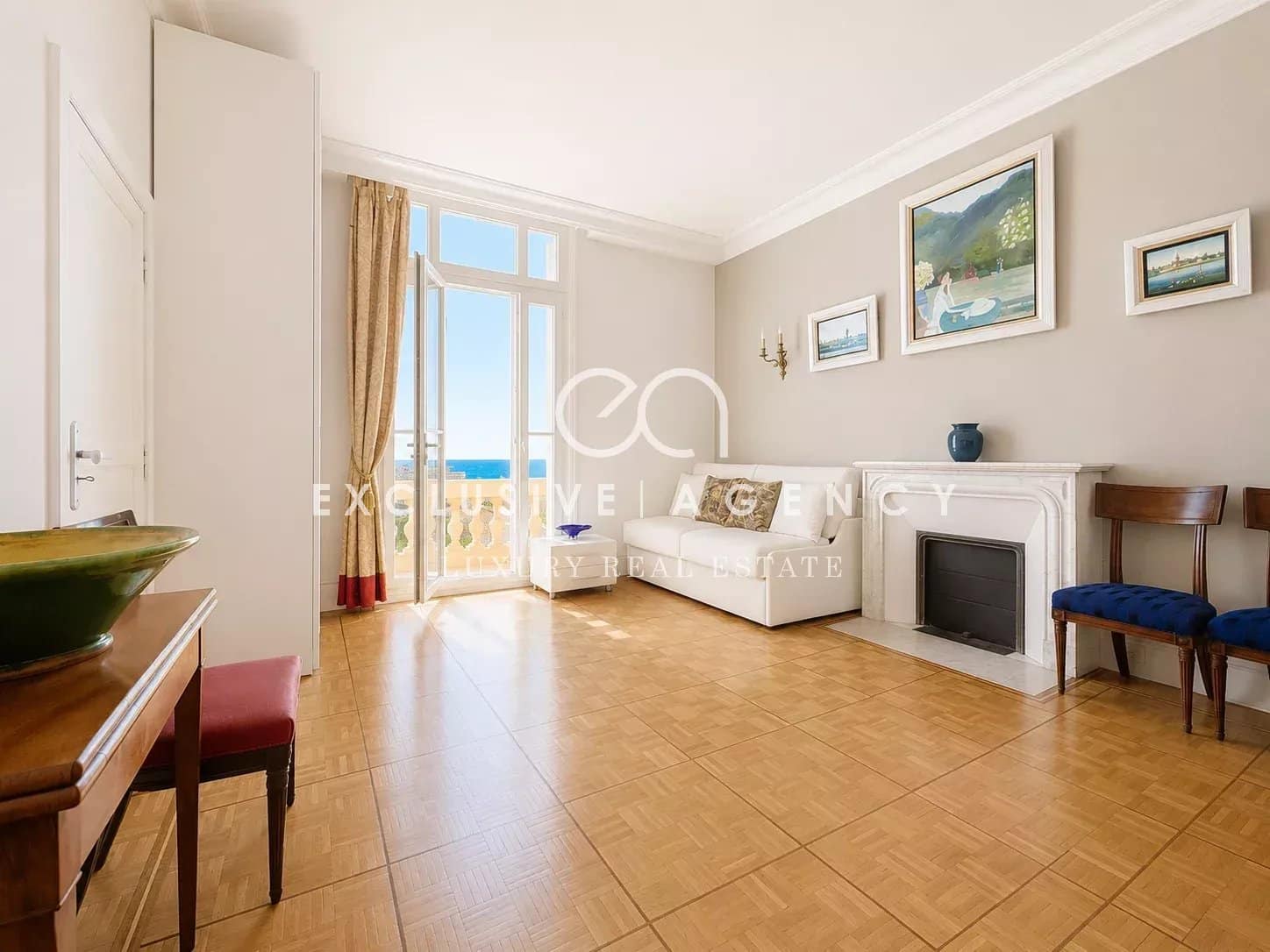 Salon d’un appartement à Cannes Salon lumineux d'un appartement à Cannes avec vue mer, parquet au sol et décoration sobre.