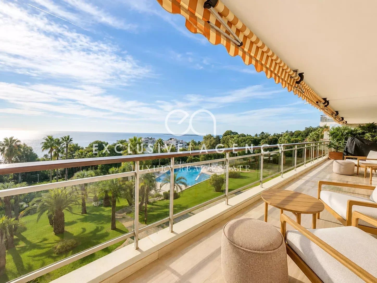 Appartement avec vue mer à Cannes Terrasse d'un appartement avec vue sur la mer et piscine, entourée de palmiers à Cannes.