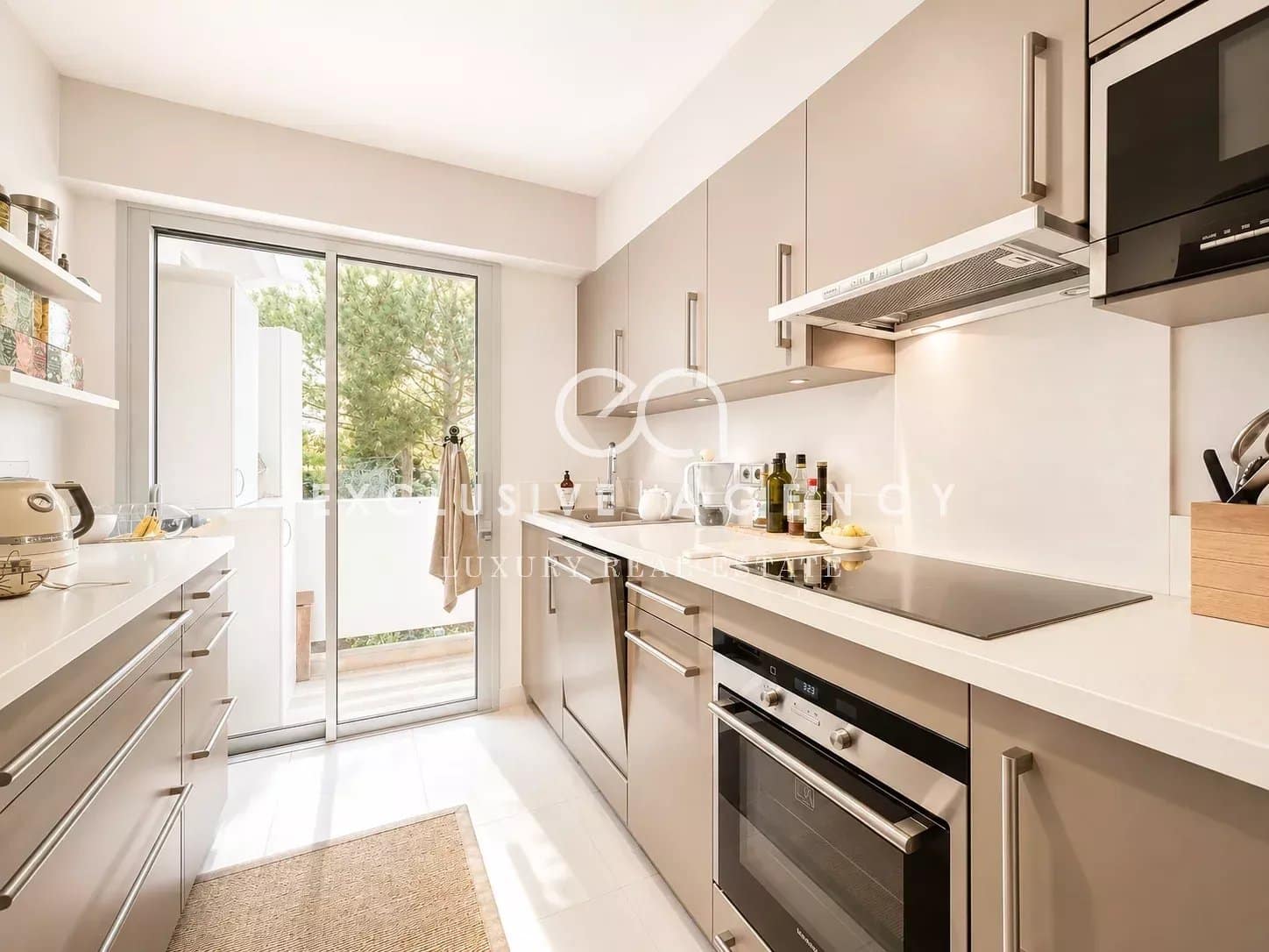 Cuisine d’un appartement à Cannes Cuisine moderne et lumineuse dans un appartement à Cannes avec accès à un balcon.