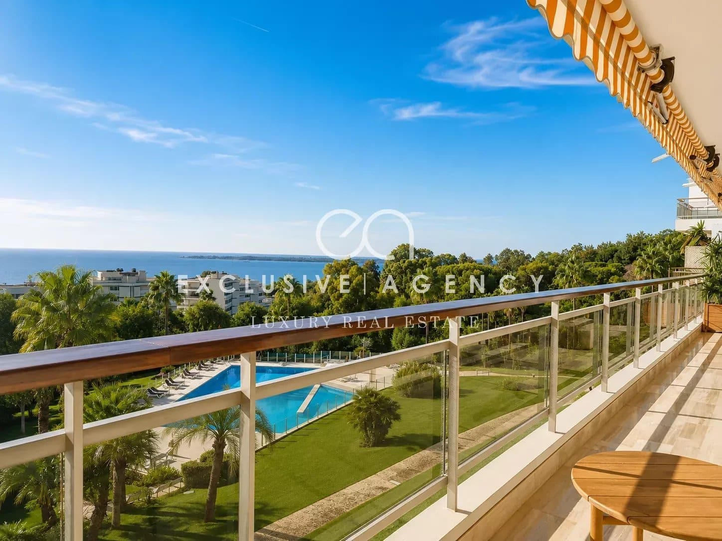Appartement avec vue mer à Cannes Balcon d'un appartement avec vue sur la mer et piscine dans un parc à Cannes.