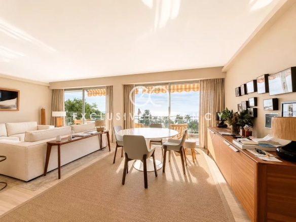 Intérieur d'un appartement spacieux avec vue sur la mer, salon lumineux et mobilier moderne.