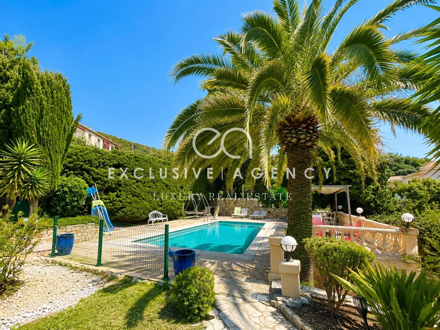 Villa for sale in Cannes Villa with pool and garden in Cannes, surrounded by palm trees and green space.