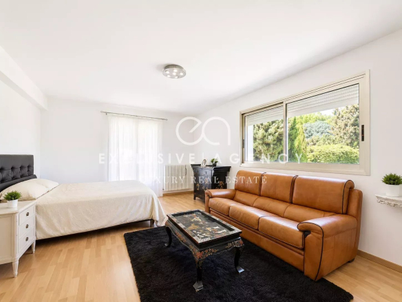 Interior of a villa in Cannes with a bed and a sofa in a bright space.