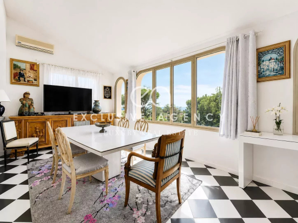 Interior of a villa in Cannes with sea view, bright dining room and elegant furniture.