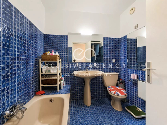 Salle de bain d'un appartement à Cannes avec carrelage bleu et baignoire