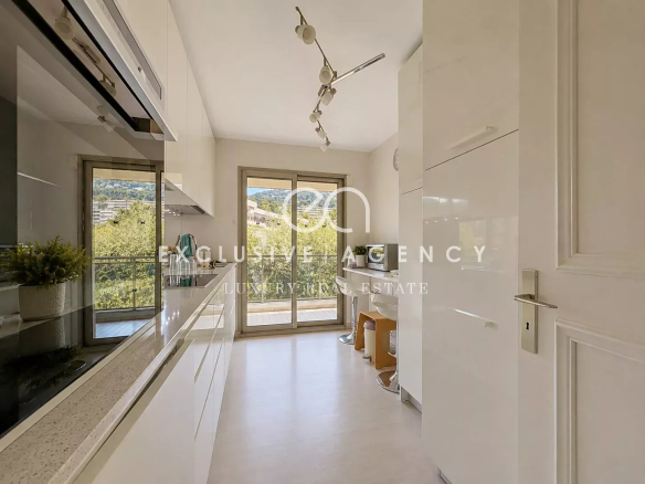Cuisine moderne et lumineuse d'un appartement à Cannes avec accès à une terrasse.