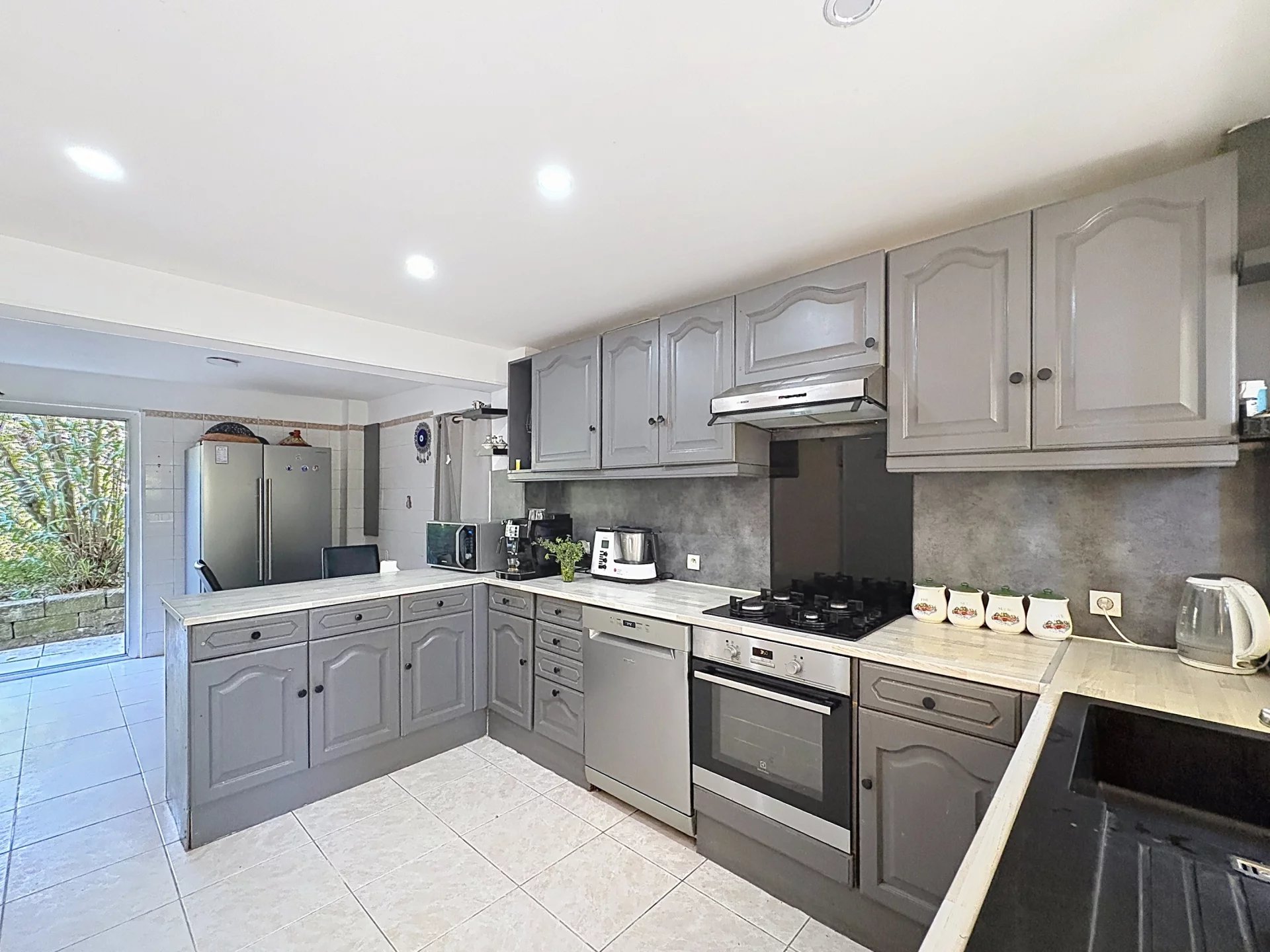Home cooking in Cannes Modern kitchen in a family home in Cannes, with grey furniture and a marble worktop.