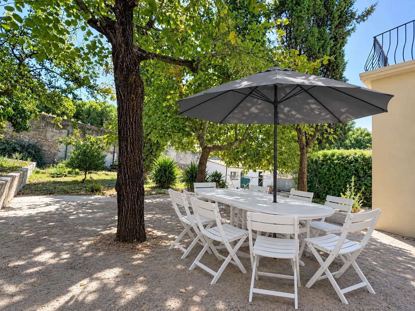 Garden with outdoor table in Cannes Outdoor table with parasol in a wooded garden, Cannes.
