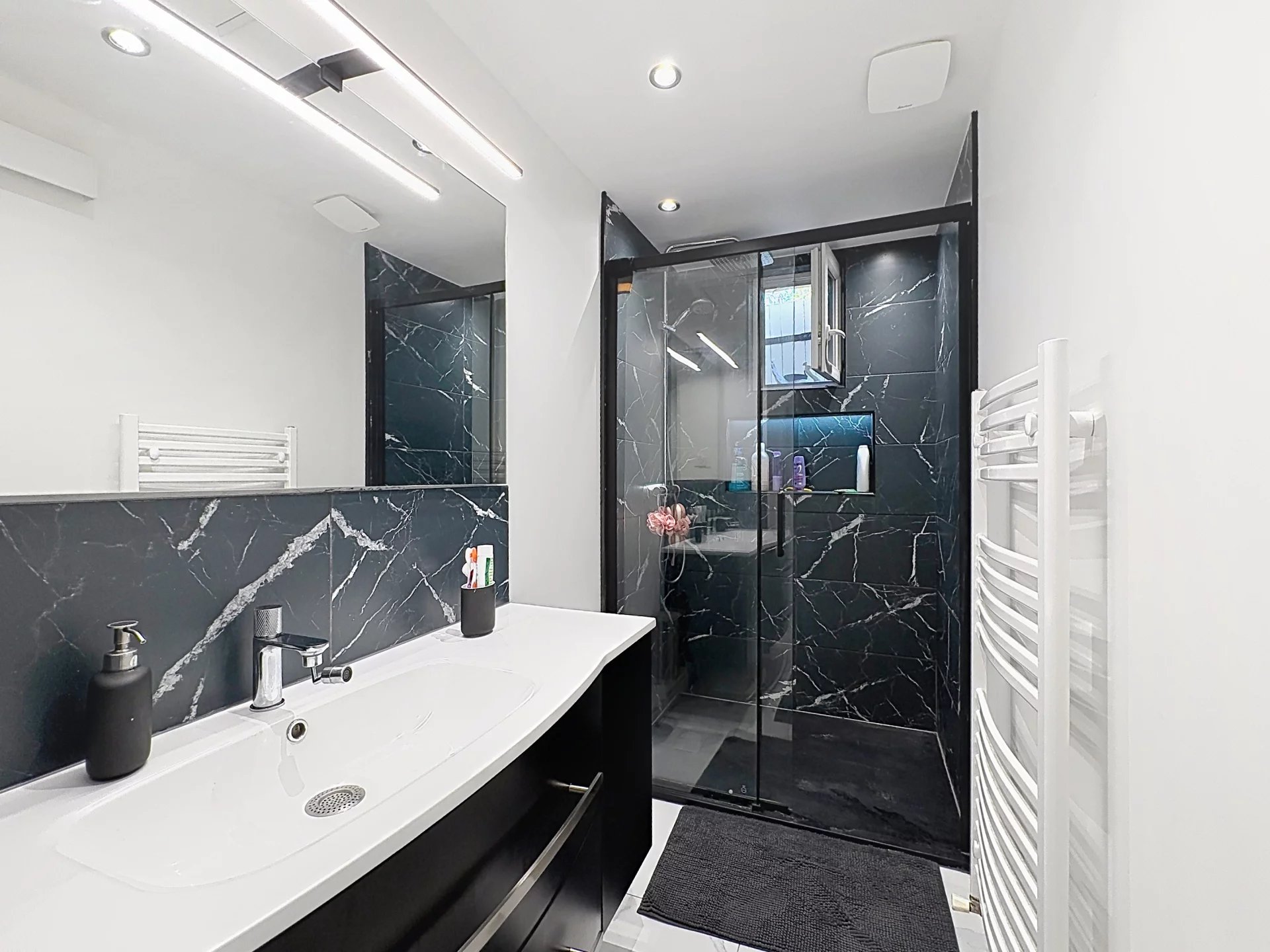Modern bathroom Modern bathroom with glass shower and sink, black marble walls.