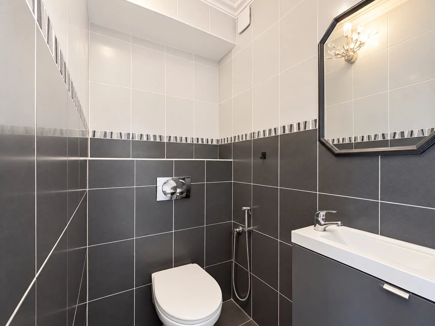 Modern bathroom Modern bathroom with grey and white tiles, sink and mirror.