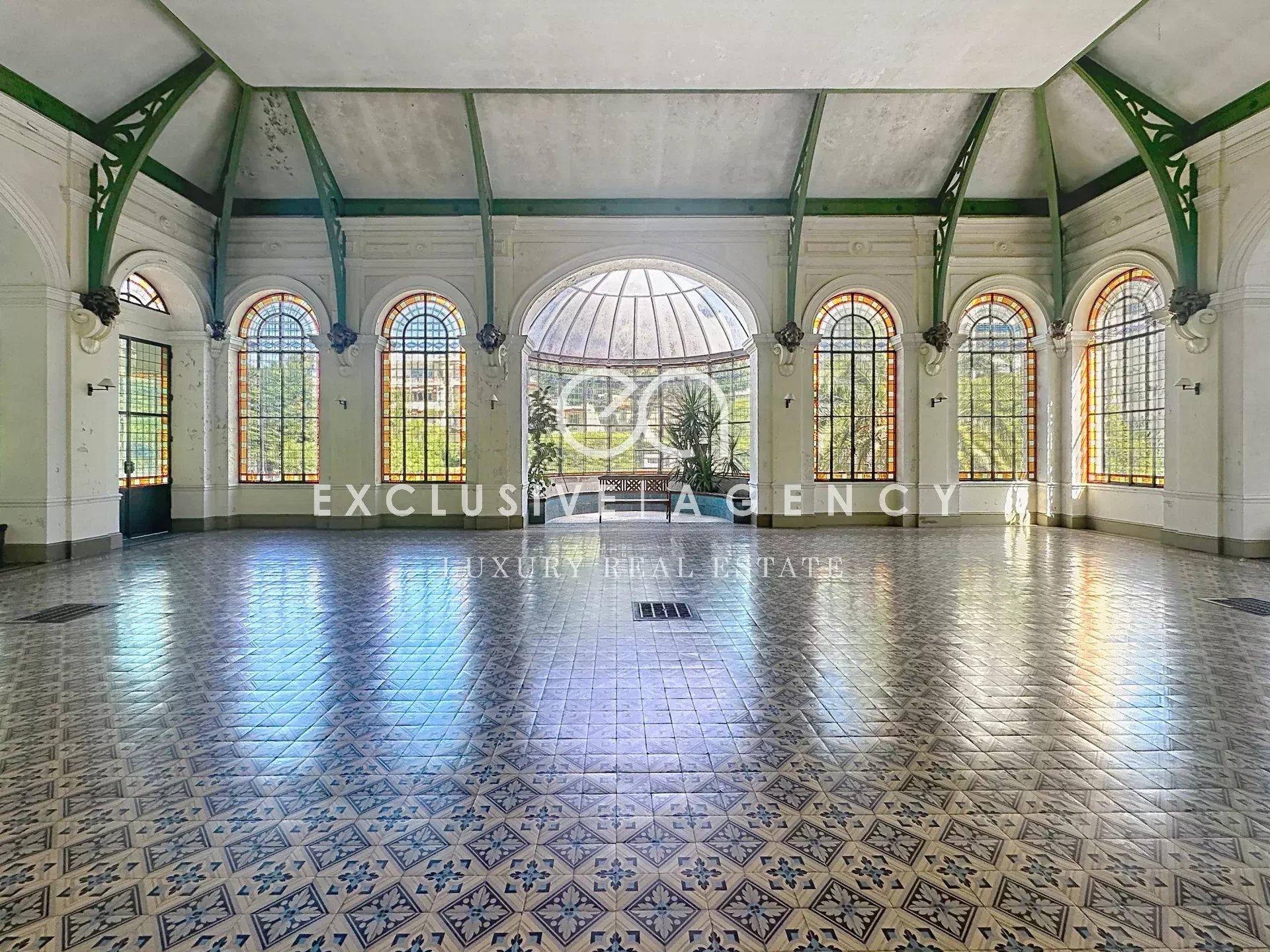 Intérieur spacieux avec fenêtres en arc Intérieur d'un grand espace lumineux avec des fenêtres en arc et un sol carrelé décoratif.