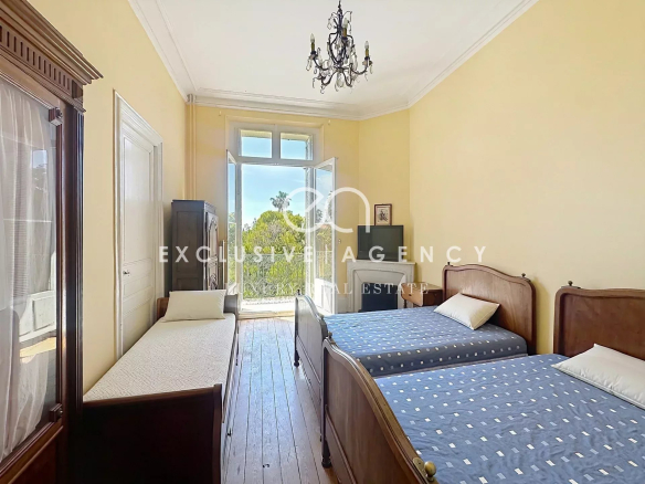 Chambre d'un appartement à Cannes avec deux lits et une fenêtre donnant sur l'extérieur.