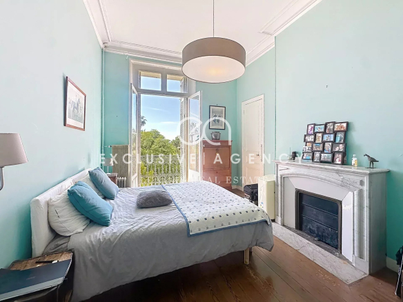 Chambre d'un appartement à Cannes avec murs turquoise et fenêtre donnant sur l'extérieur.