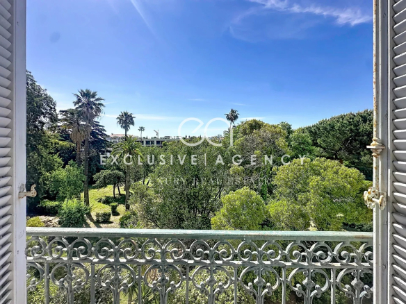 Vue depuis un balcon sur un jardin verdoyant avec des palmiers à Cannes.