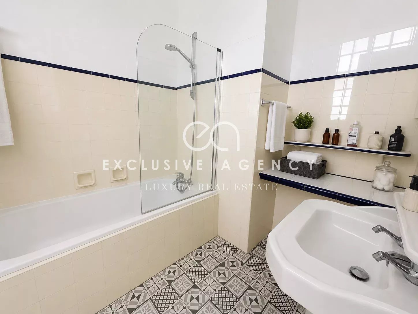Salle de bain d’un appartement à Cannes Salle de bain moderne avec baignoire et douche, carrelage décoratif.