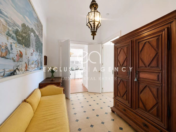 Entrée d'un appartement de 3 pièces avec un canapé jaune et des portes ouvertes sur un séjour lumineux.
