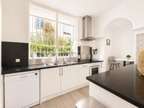 Cuisine moderne et lumineuse d'une villa individuelle à Cannes, avec plans de travail en noir et appareils électroménagers.