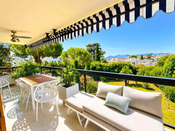 Terrasse d'un appartement avec mobilier moderne et vue sur jardins et montagnes à Cannes