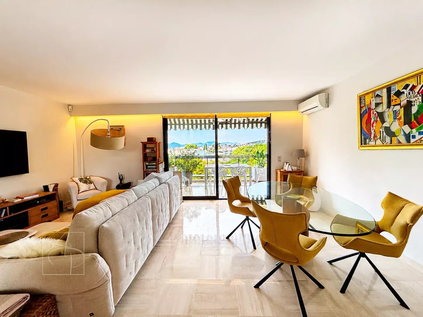 Séjour lumineux d'un appartement de 2 pièces à Cannes avec vue sur jardins et aperçu mer.