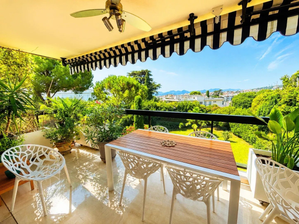 Terrasse spacieuse avec mobilier de jardin et vue sur jardins et mer à Cannes.