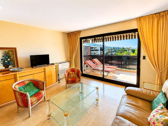 Bright living room of an apartment with sea views in Cannes, large bay windows and modern furniture.