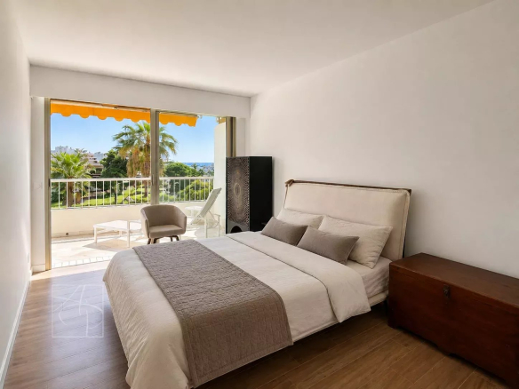 Chambre d'un appartement élégant à Cannes avec terrasse et vue sur la mer.