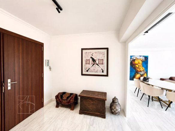 Entrée d'un appartement élégant avec décoration artistique et mobilier en bois.