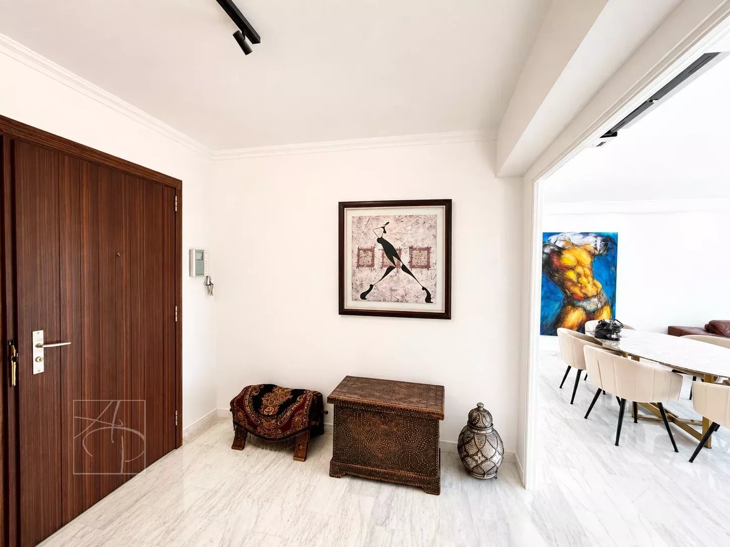 Entrée d'un appartement élégant avec décoration artistique et mobilier en bois.