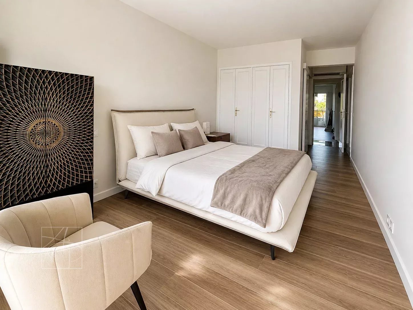 Chambre d'un appartement élégant à Cannes, avec un lit double et un mobilier moderne.