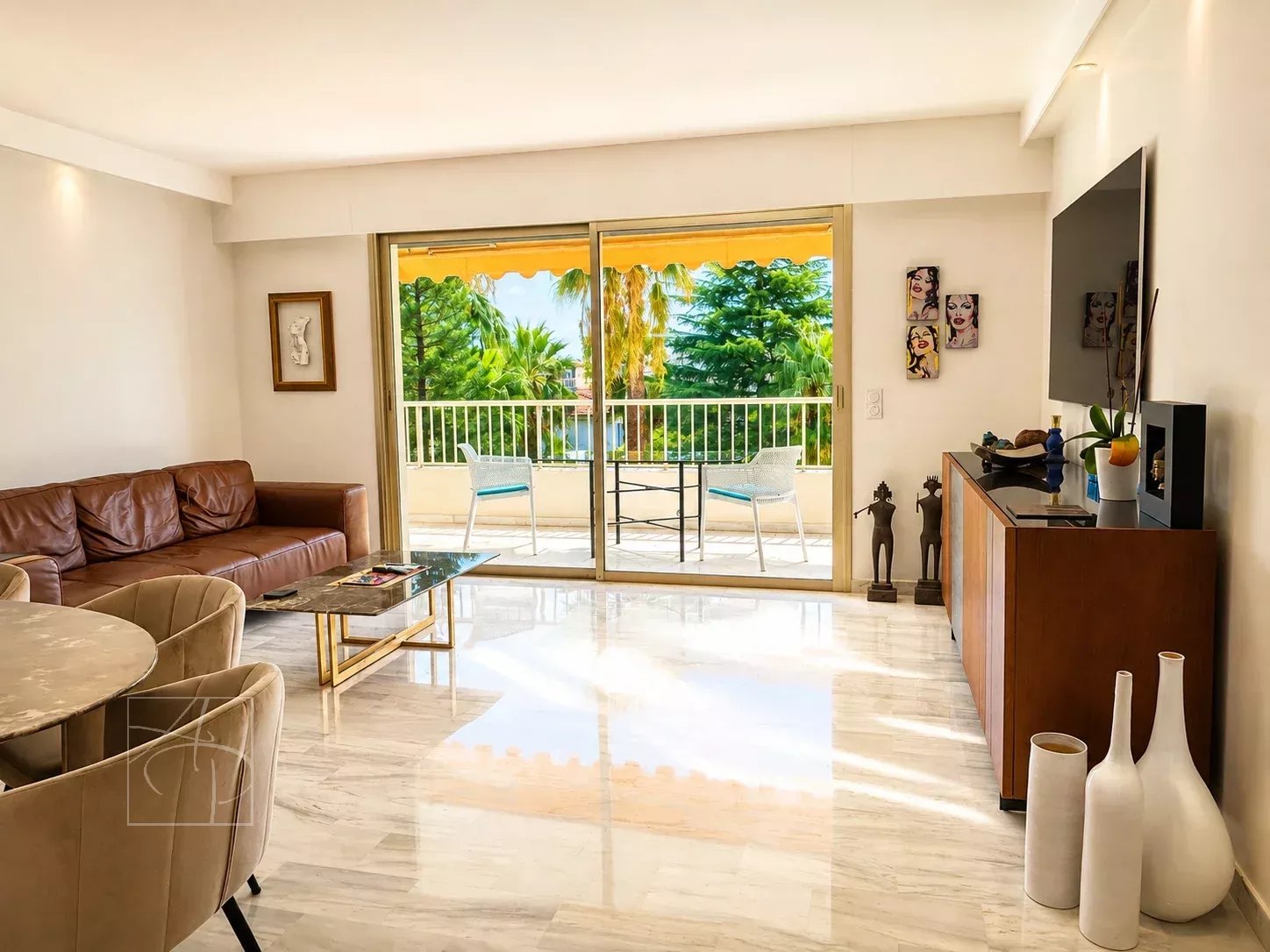 Salon lumineux d'un appartement avec terrasse, vue sur la verdure et mobilier moderne.
