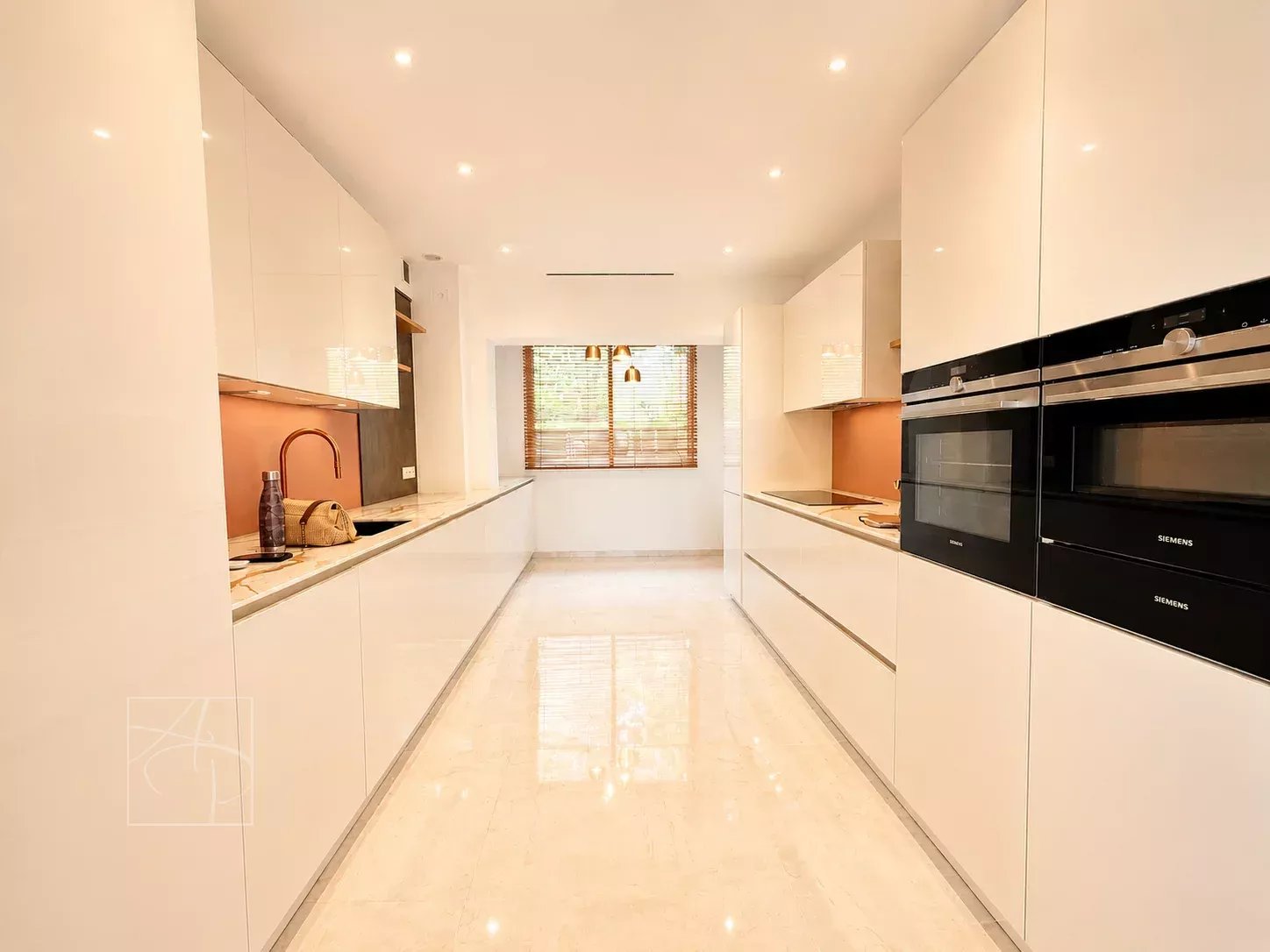Modern and bright kitchen with white furniture and integrated appliances.