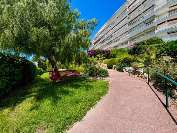 Chemin menant à un bâtiment résidentiel entouré de verdure à Cannes Montfleury.