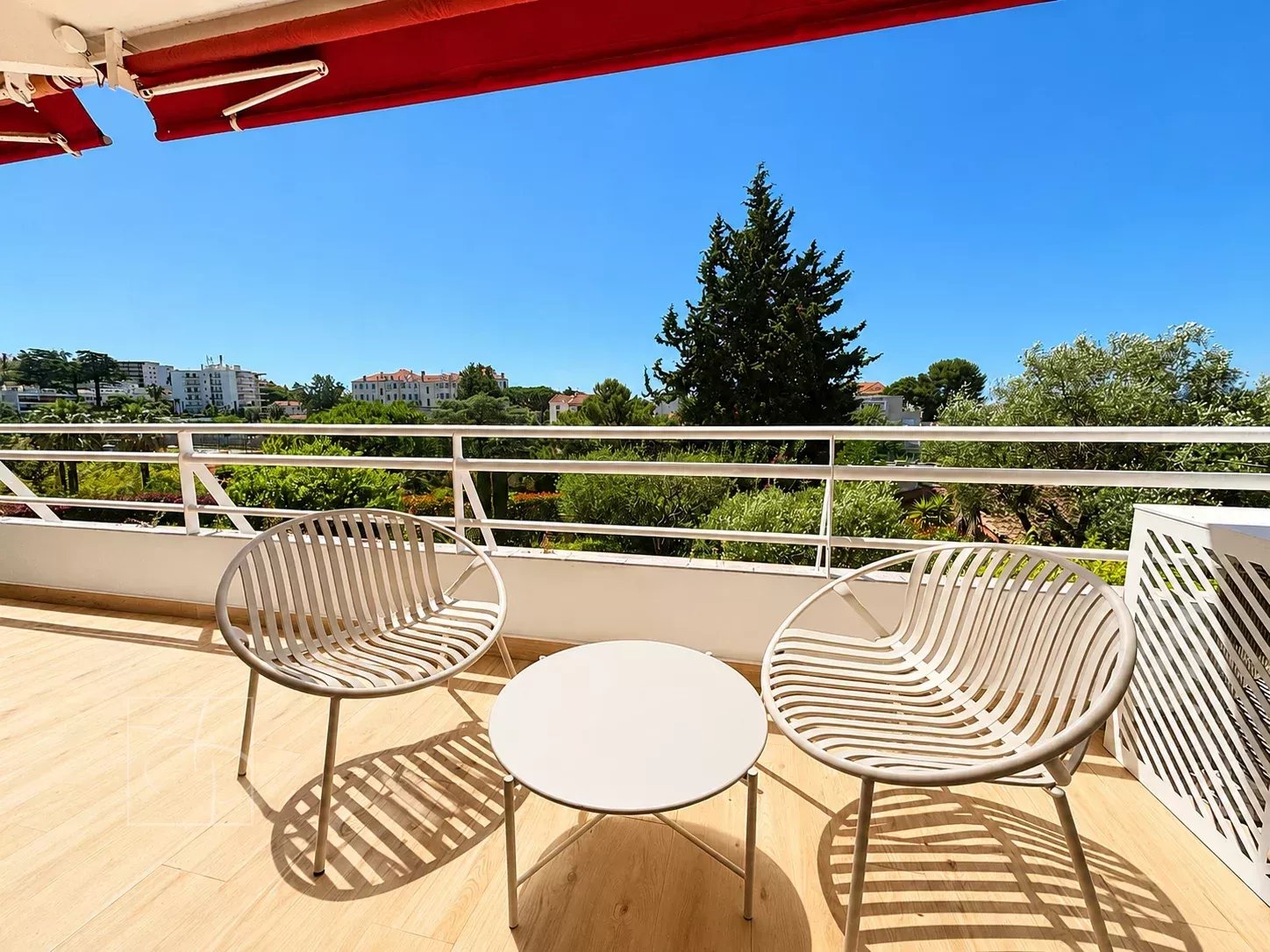 Terrasse ensoleillée avec fauteuils et vue sur la verdure à Cannes Montfleury.