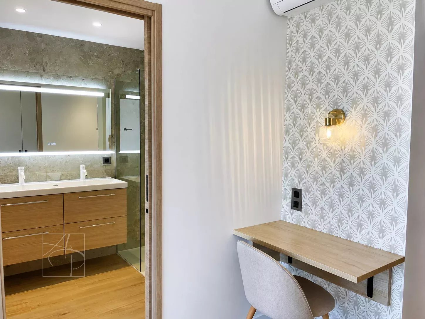 Intérieur d'un appartement avec salle de bains moderne et coin bureau.