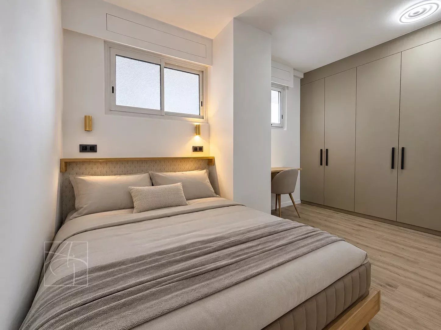 Chambre d'un appartement moderne avec lit double, bureau et rangements à Cannes Montfleury.