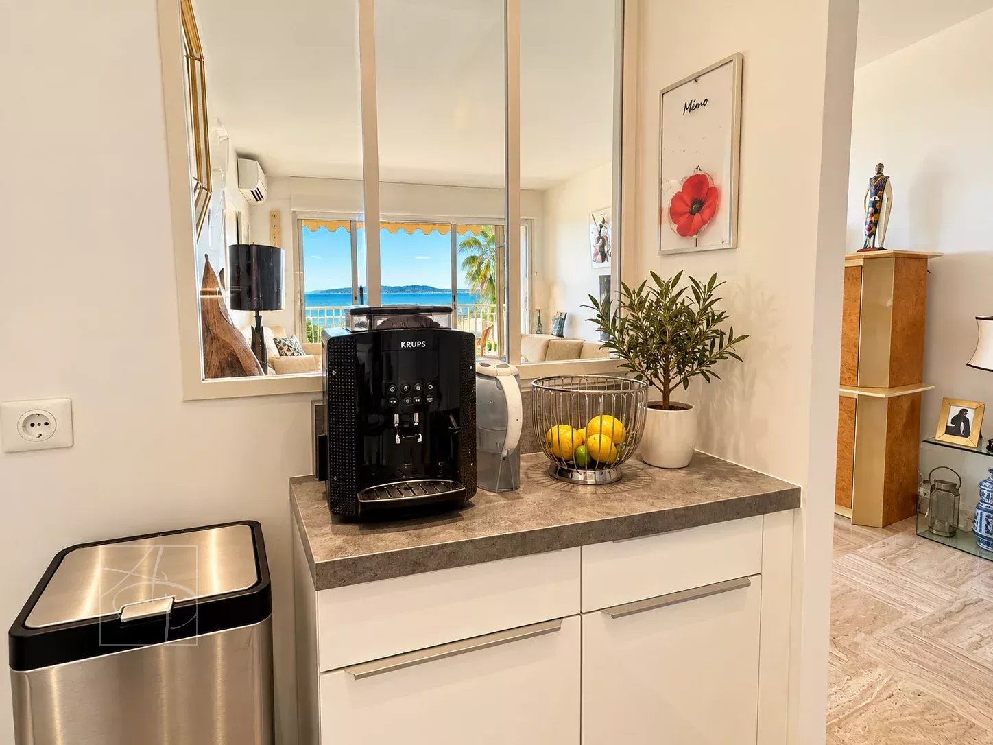 Appartement avec vue mer à Cannes Intérieur d'un appartement avec vue sur la mer à Cannes, incluant un coin cuisine et une terrasse.
