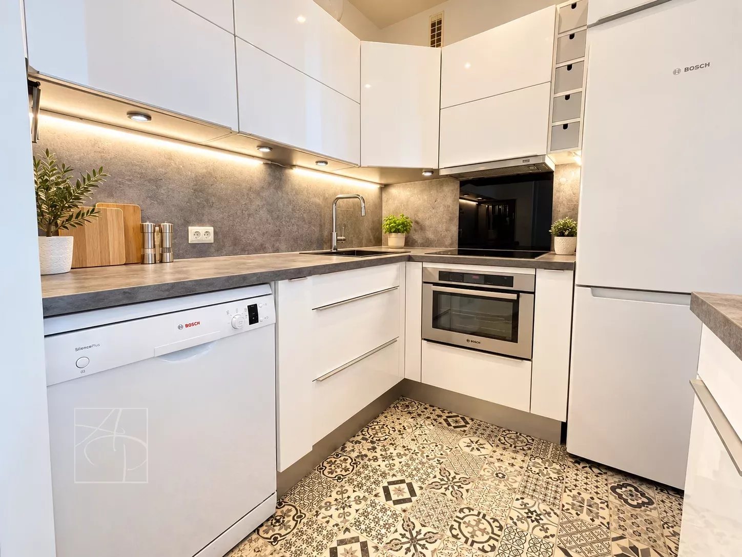 Cuisine d’un appartement à Cannes Cuisine moderne et élégante d'un appartement à Cannes, avec des équipements intégrés et un sol en carrelage décoratif.