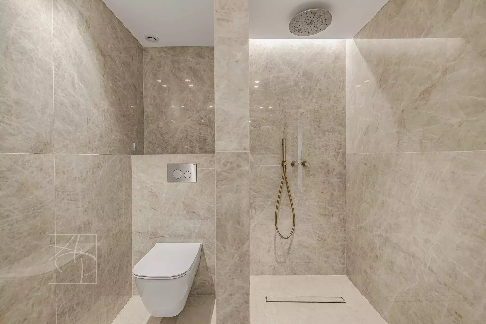 Renovated bathroom Modern bathroom with shower and toilet, clad in marble.