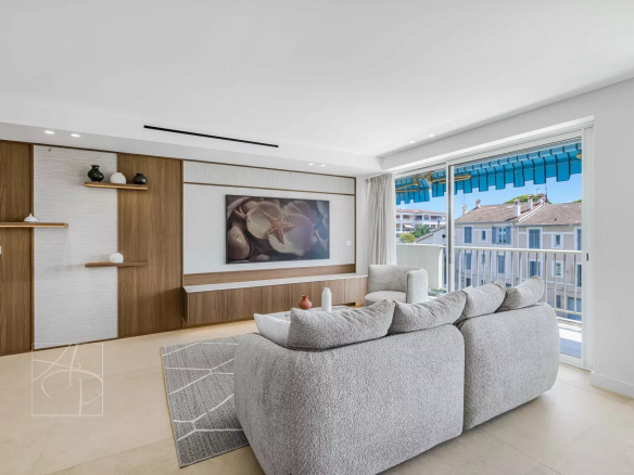 Bright living room of a renovated apartment with a glimpse of the sea in Cannes, modern furniture and contemporary decor.