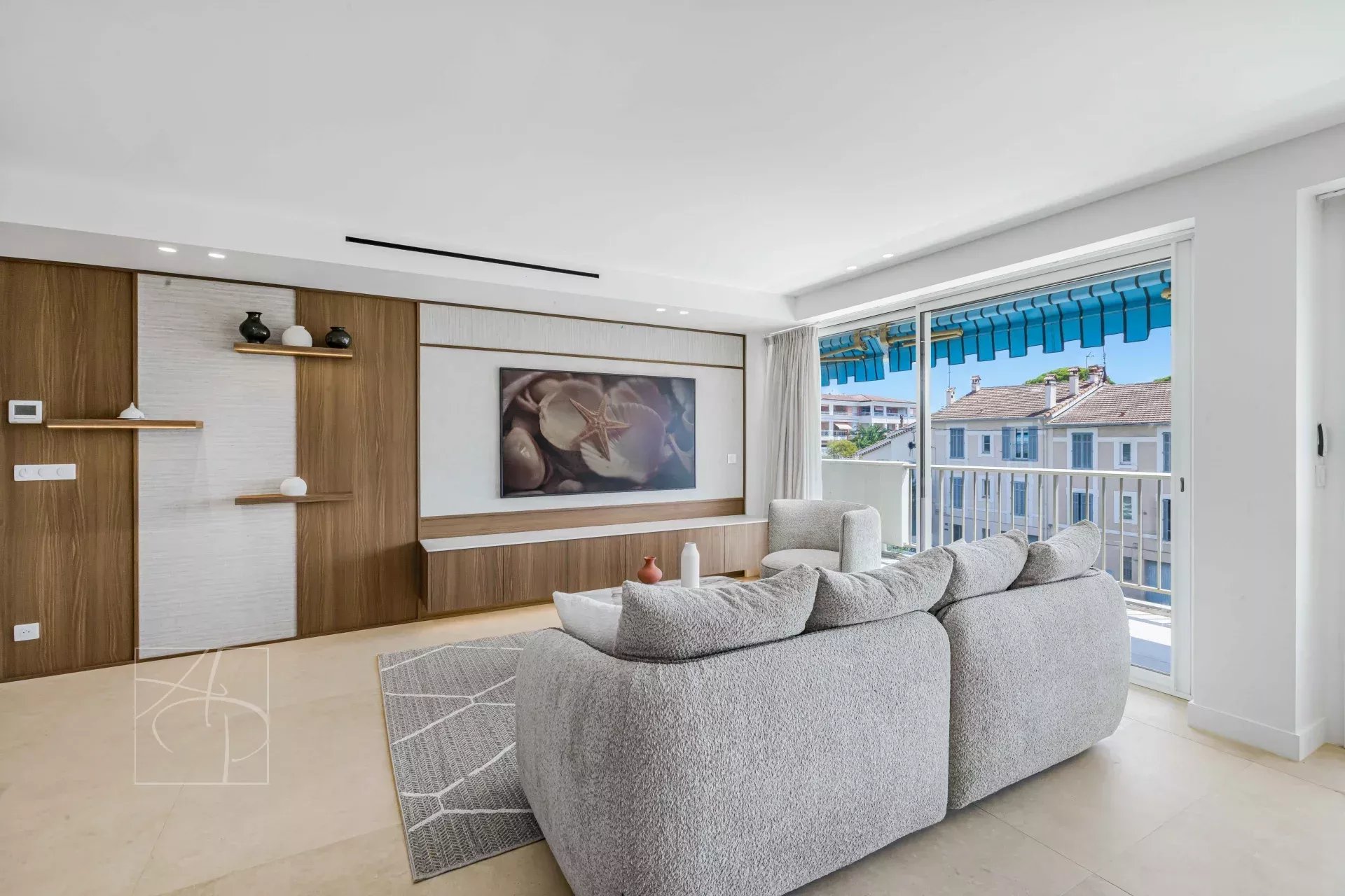 Living room of a renovated apartment in Cannes Bright living room of a renovated apartment with a glimpse of the sea in Cannes, modern furniture and contemporary decor.