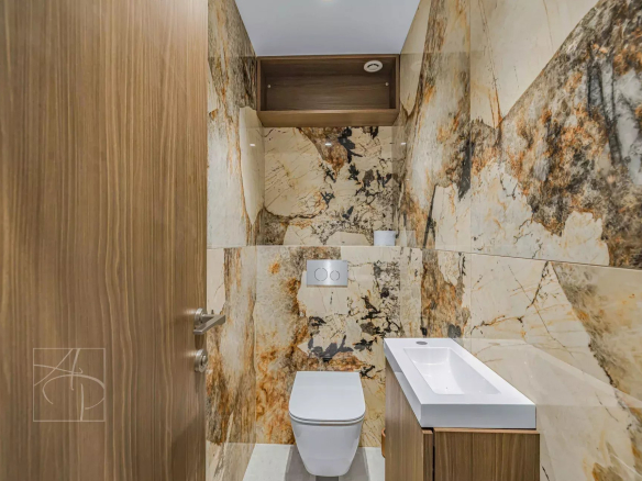 Modern bathroom with marble tiles and separate toilet.