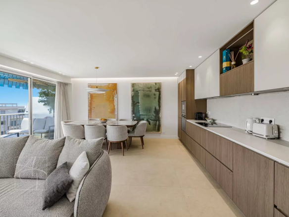 Interior of a renovated apartment in Cannes with living room, dining room and modern kitchen.