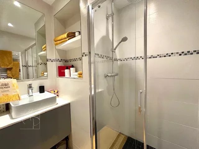 Bathroom of a renovated apartment in Cannes Modern bathroom with walk-in shower and sink in a renovated apartment.