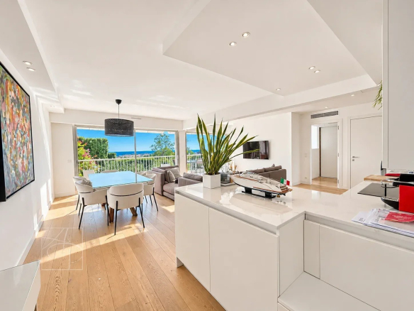 Intérieur d'un appartement rénové à Cannes avec vue sur la mer et luminosité.