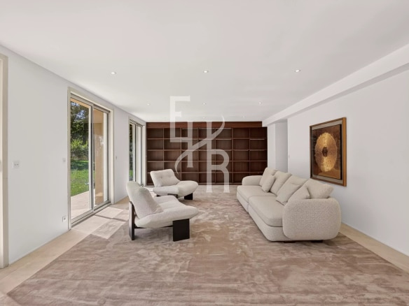 Intérieur d'une villa moderne à Mougins avec un salon lumineux et des fenêtres donnant sur le jardin.